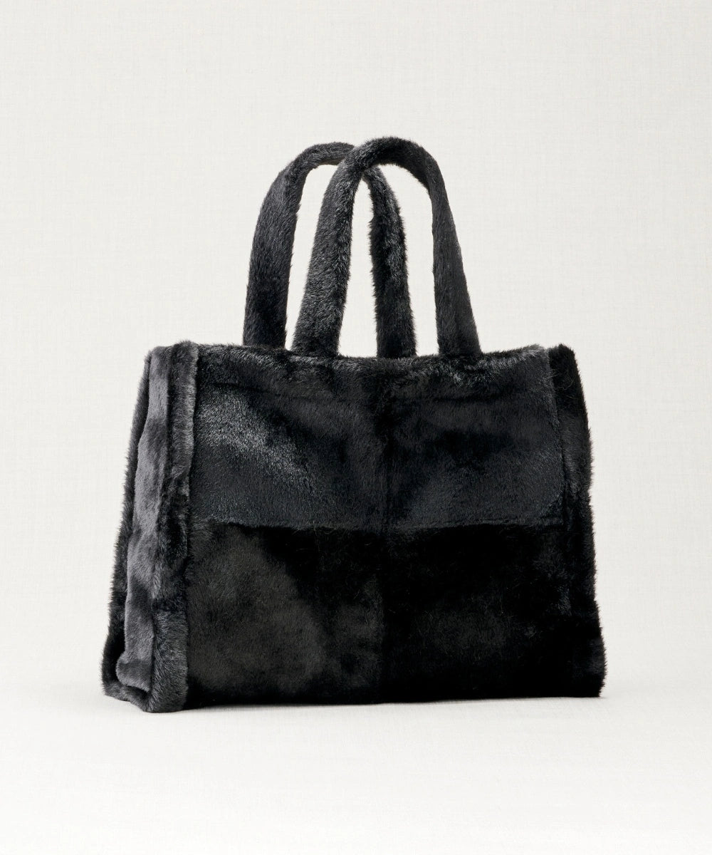 Sac cabas fausse fourrure waro posé sur un fond beige