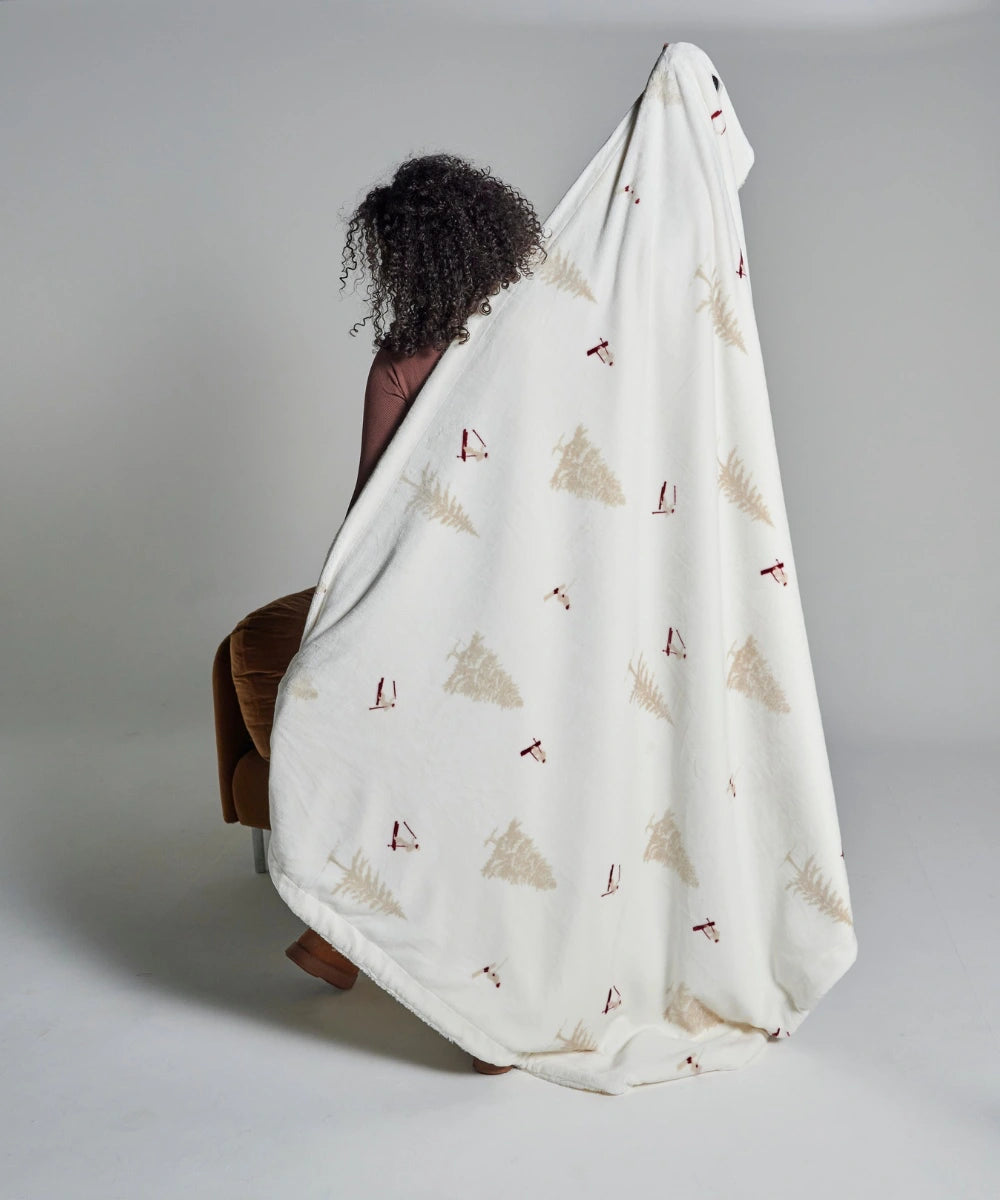 Fleece blanket with skier waro motif held by a woman seen from behind