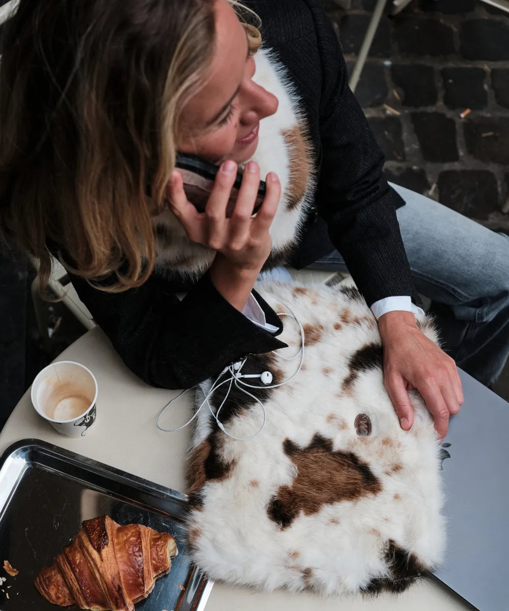 Pochette ordi fourrure waro vache posé sur une table