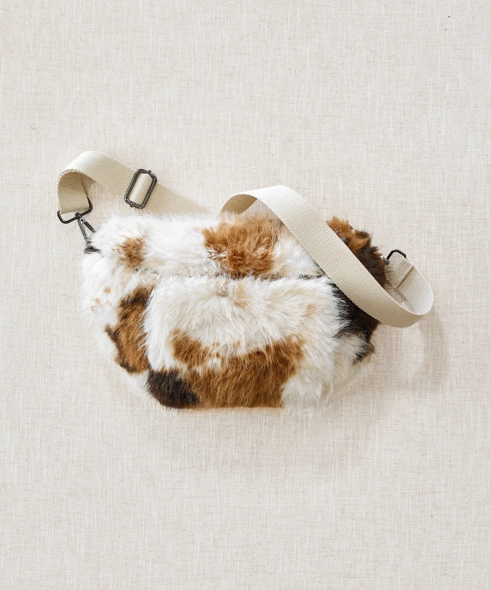 Banane fausse fourrure motif vache waro posé à plat sur un fond beige 