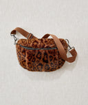 Sac banane fausse fourrure léopard marron waro posé à plat sur un fond beige
