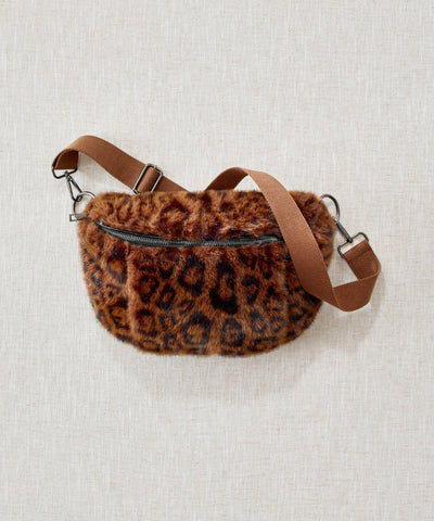 Sac banane fausse fourrure léopard marron waro posé à plat sur un fond beige