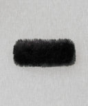 Bandeau fourrure noir waro posé à plat sur un fond beige