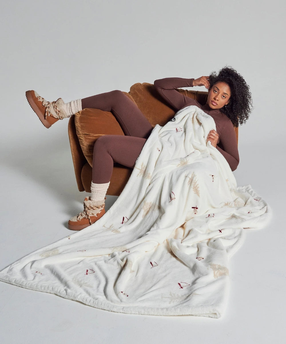 Fleece blanket with skier waro pattern on a woman sitting on an armchair