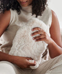 Bouillotte galet fourrure waro posé dans les mains d’une femme