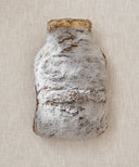 Bouillotte frisson fourrure waro posé à plat sur un fond beige 