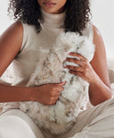 Bouillotte leopard des neiges fourrure waro dans les mains d’une femme