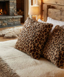 Coussin léopard waro posé sur un lit 