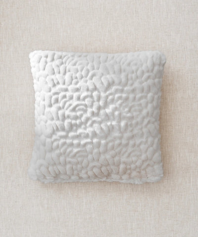 Coussin galet blanc waro posé a plat sur un fond beige