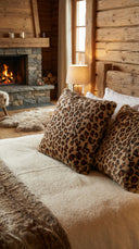 Coussin léopard waro posé sur un lit dans un chalet 