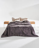 Couvre-lit king size gris en polaire épaisse, couvrant entièrement le lit, présenté en studio sur fond blanc avec tables de chevet en bois clair.