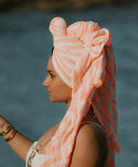 Fouta rayée orange et blanc WARO portée en turban, accessoire de plage en coton naturel