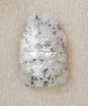 Bouillotte-leopard des neiges fourrure waro posé à plat sur fond beige 