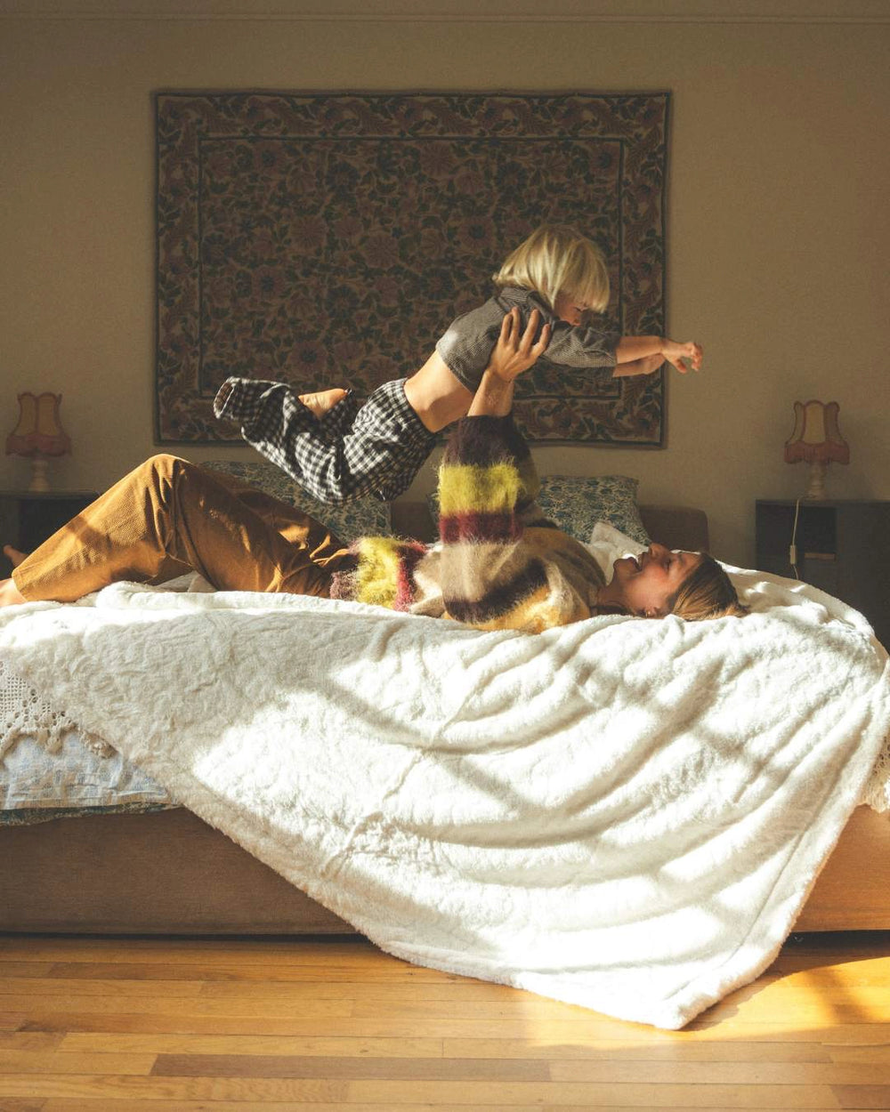 Couvre-lit king size ours blanc waro posé sur un lit avec un enfant et une femme