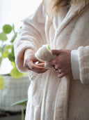 Peignoir polaire écru WARO – détail des mains tenant la ceinture