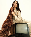 Plaid fausse fourrure Sauvage WARO posé sur TV vintage