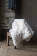 Plaid Polaire Bébé Berbère WARO posé sur une chaise en bois