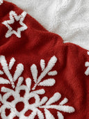 Détail du plaid cocoon des neiges rouge WARO avec motifs flocons en relief et texture polaire ultra douce.
