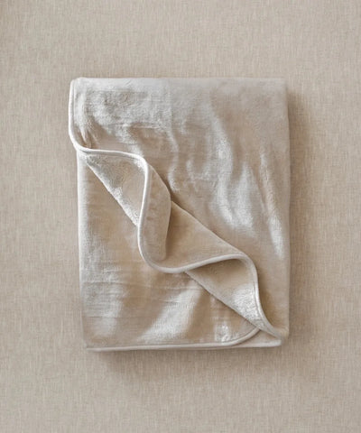 Plaid cosy beige waro posé à plat sur un fond beige