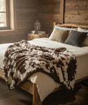 Plaid fausse fourrure far west waro posé sur un lit