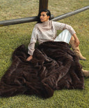 Plaid fausse fourrure waro marron sur une femme posé au sol 