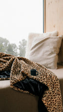 Plaid fausse fourrure léopard waro posé sur un banc dans un chalet