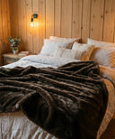 Plaid fausse fourrure polar marron posé sur un lit