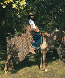 Plaid fausse fourrure leopard waro posé autours d’une femme assise sur un cheval 