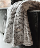 Plaid polaire waro nougatine posé sur un canapé gris 