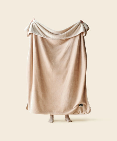 Plaid polaire cosy beige waro tendu par une personne