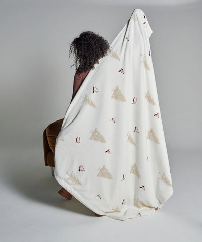 Fleece blanket with skier waro motif held by a woman seen from behind