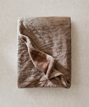 Plaid polaire tigre taupe waro posé à plat sur un fond beige 