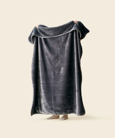 Plaid polaire cosy gris anthracite waro tendu par une personne