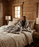 Plaid fausse fourrure gris waro autour d’une femme sur un lit