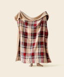 Plaid télécabine beige waro polaire tendu par une personne sur un fond beige  