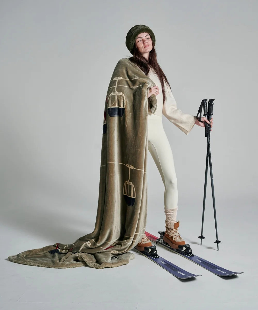 Waro taupe gondola fleece blanket held by a woman 