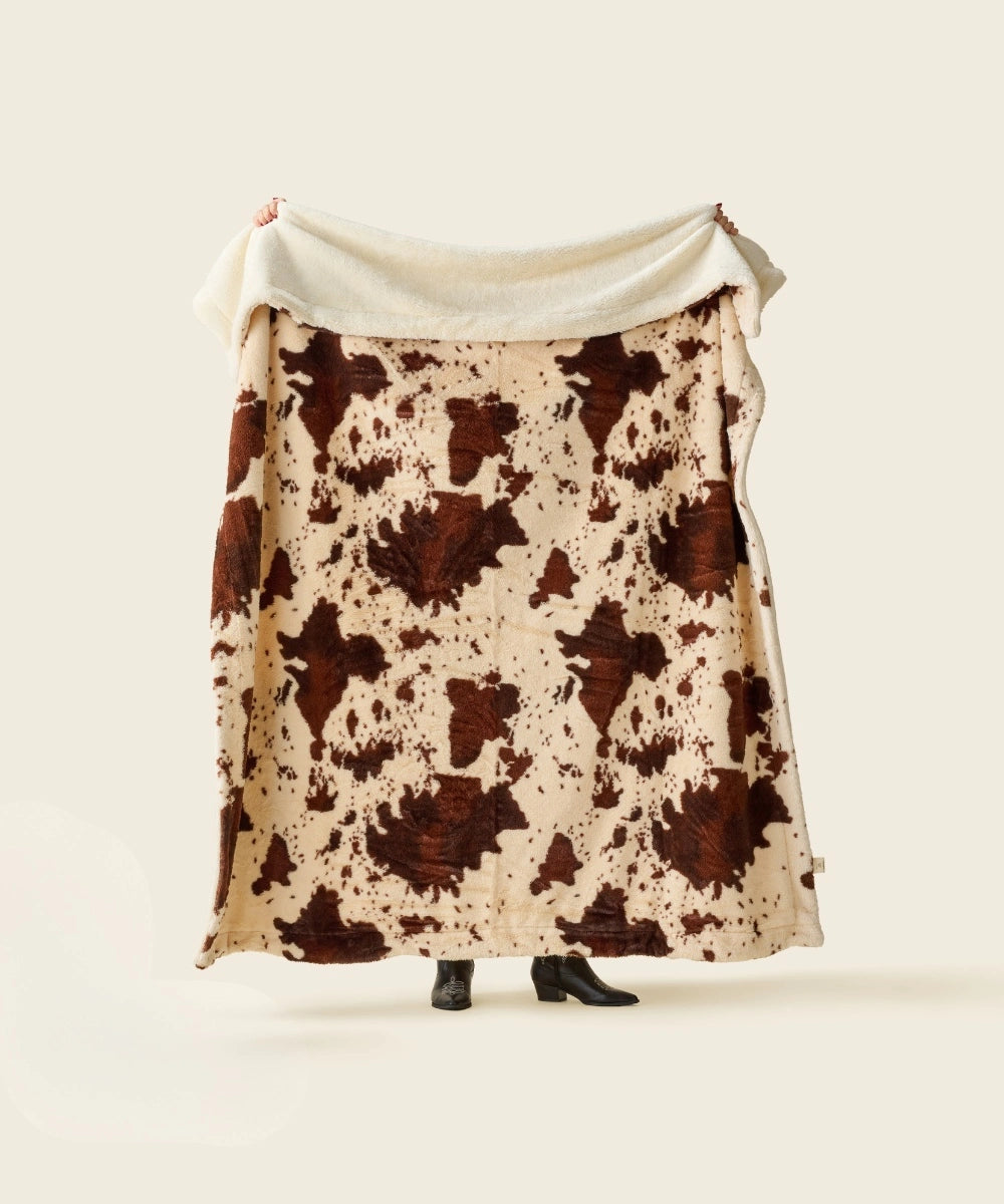 Plaid polaire cow waro tendu par une personne 