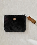 Pochette fourrure noir waro posé à plat sur fond beige