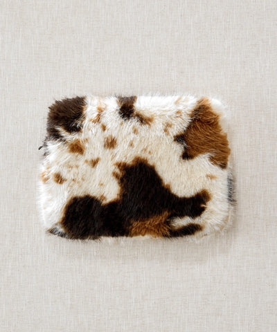 pochette ordinateur waro fausse fourrure vache posé à plat sur un fond beige 
