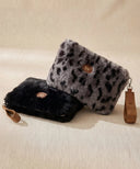 Pochette zippée léopard gris WARO en fausse fourrure associée à une pochette noire fourrure