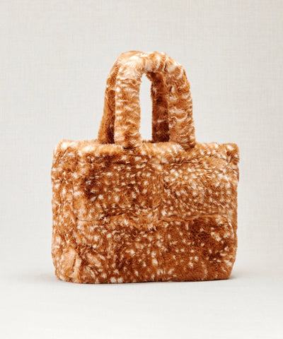 Sac fausse fourrure motif bambi posé sur un fond beige 