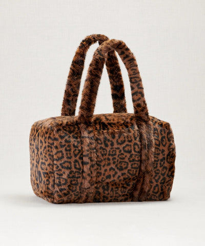 Sac weekender fausse fourrure waro posé sur un fond beige 
