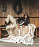 Plaid fausse fourrure waro beige sur un banc avec une femme posé au 