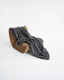 Plaid fausse fourrure waro gris posé sur un canapé taupe