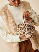 Trousse fourrure leopard waro tenu dans les mains d’une femme