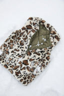 Veste kaki léopard waro posé dans la neige 