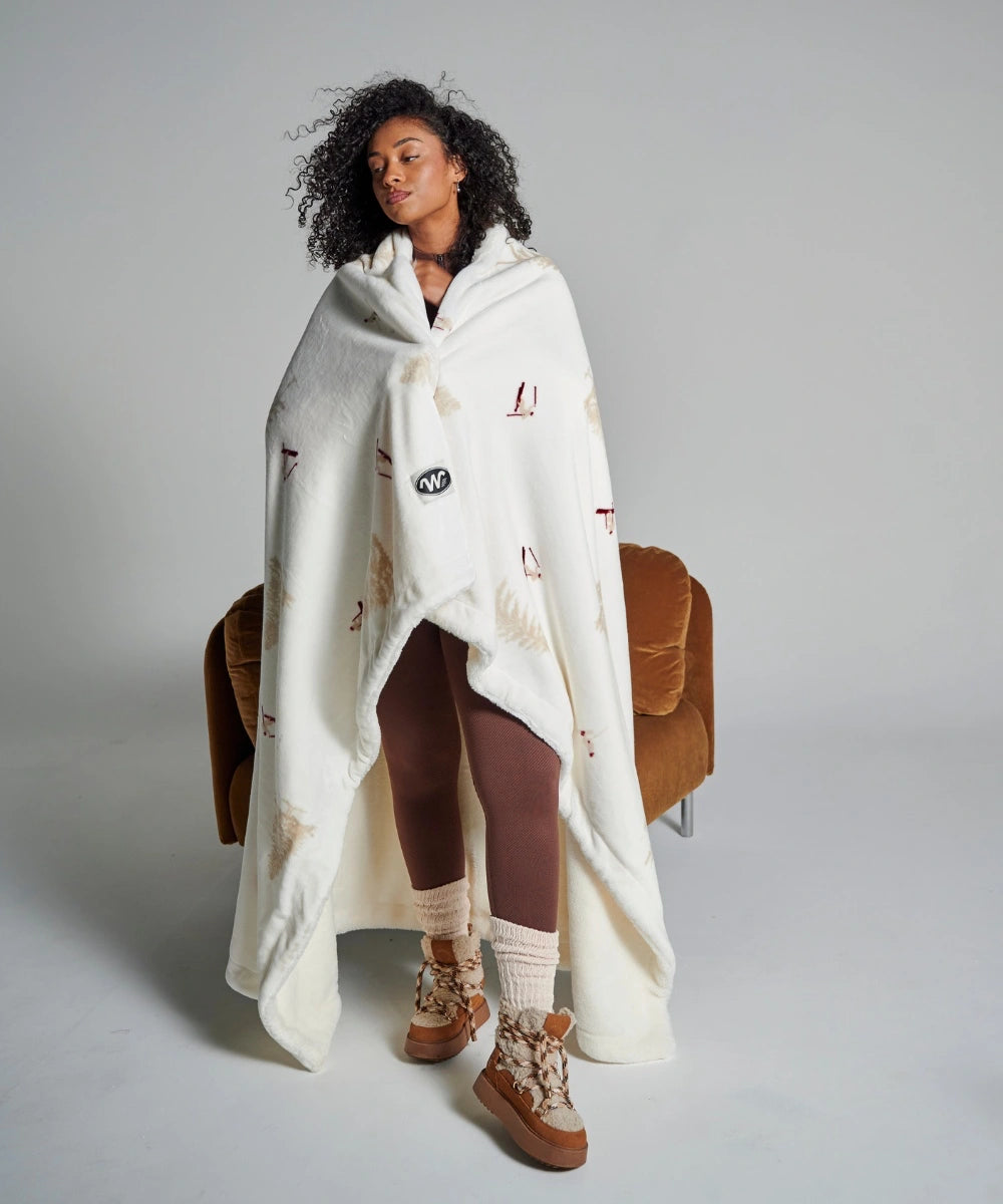 Fleece blanket with skier motif wrapped around a woman
