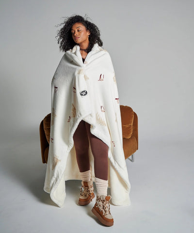 Fleece blanket with skier motif wrapped around a woman