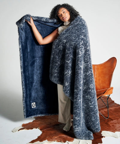 Plaid en fausse fourrure bleu nuit waro enroulé autours d’une femme debout