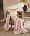 Plaid polaire cosy rose waro posé sur une chaise